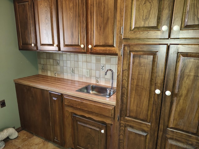 bar featuring backsplash and a sink