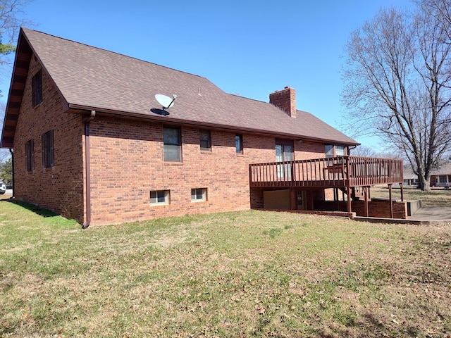 back of house featuring a deck, a lawn, brick siding, and a chimney