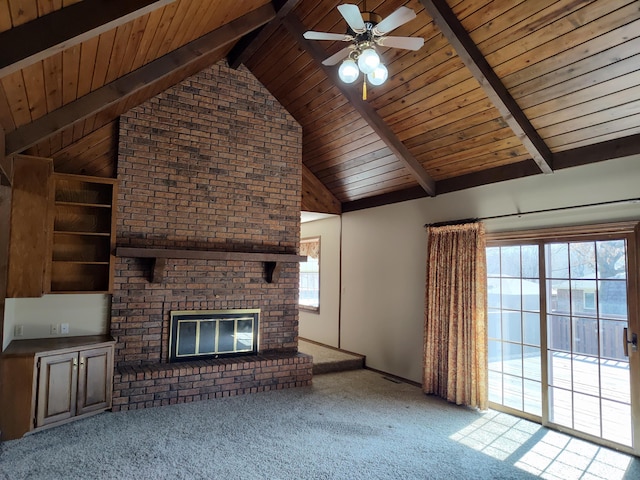 unfurnished living room with a wealth of natural light, carpet flooring, beamed ceiling, and a ceiling fan