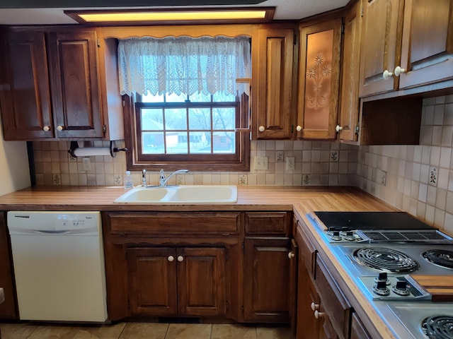 kitchen featuring butcher block countertops, decorative backsplash, stainless steel electric stovetop, white dishwasher, and a sink