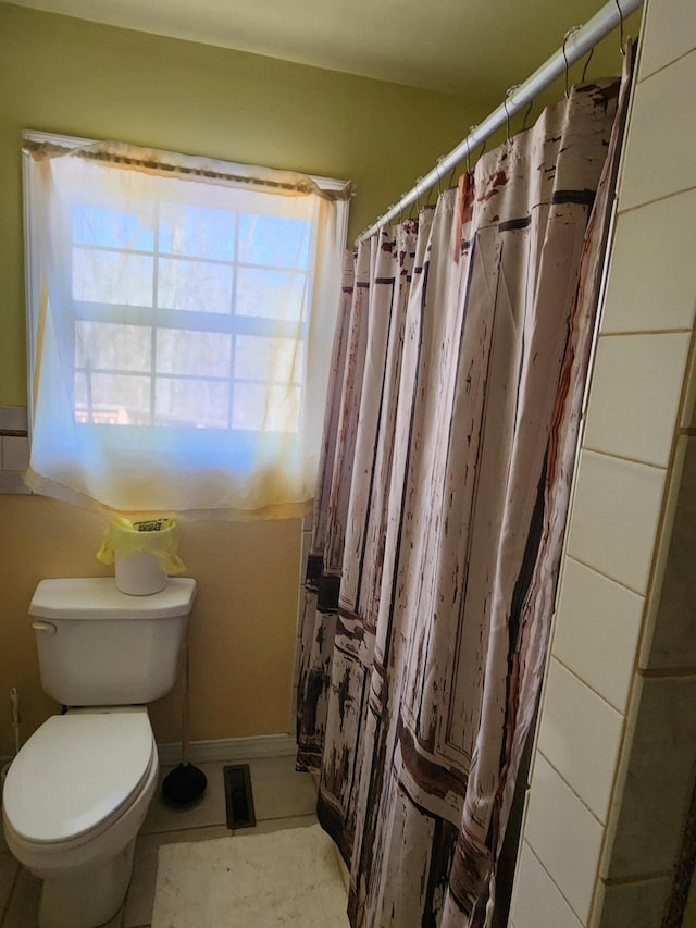 full bathroom featuring toilet and a shower with shower curtain