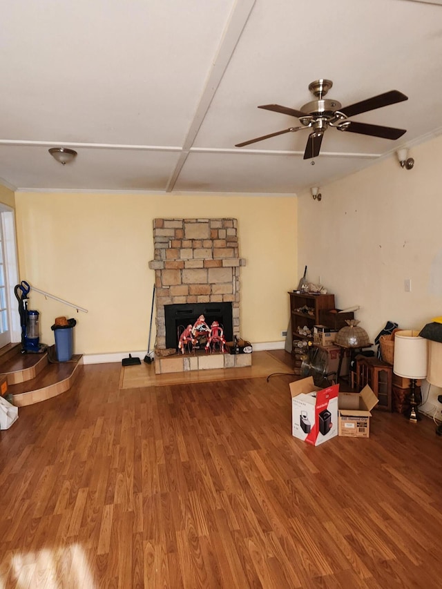 living area with a fireplace, baseboards, a ceiling fan, and wood finished floors