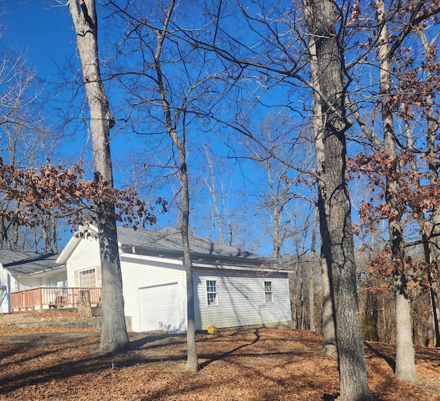 back of property featuring a garage and a deck