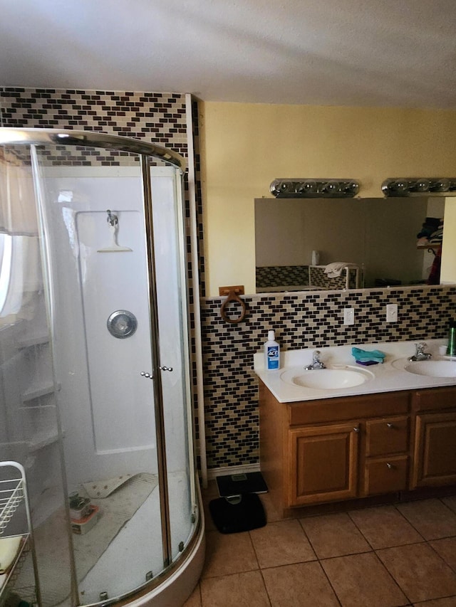 full bath with tile patterned flooring, double vanity, a stall shower, and a sink