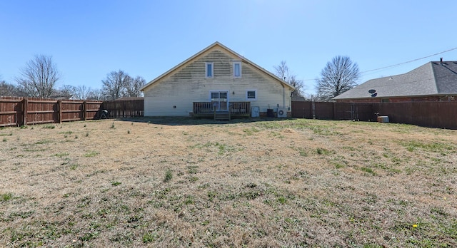 rear view of property with a lawn and a fenced backyard