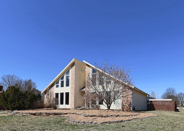 view of home's exterior featuring fence and a lawn