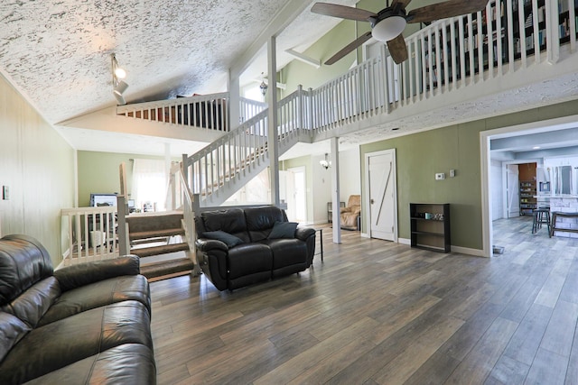 living room with baseboards, ceiling fan, stairs, wood finished floors, and a textured ceiling