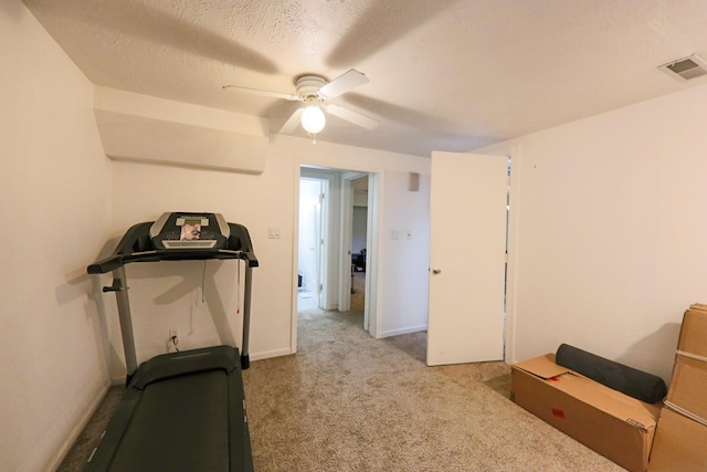 workout room featuring a ceiling fan, baseboards, visible vents, carpet floors, and a textured ceiling