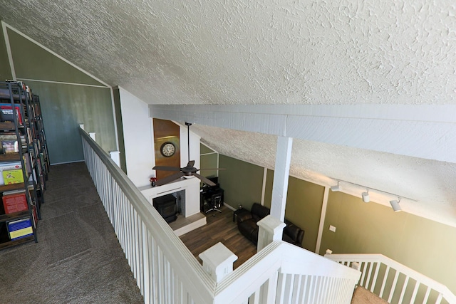 staircase featuring lofted ceiling, a textured ceiling, and ceiling fan