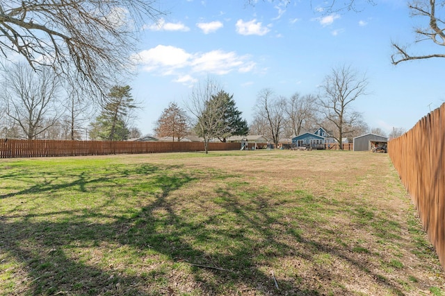 view of yard with an outdoor structure and a fenced backyard