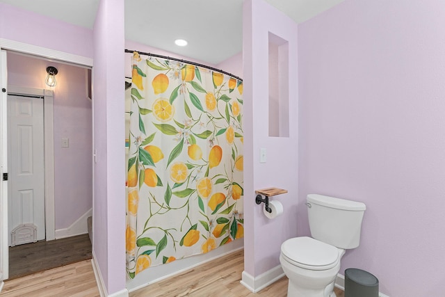 bathroom featuring curtained shower, baseboards, toilet, and wood finished floors