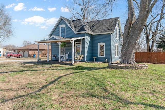 view of front of house featuring covered porch, a front yard, and fence