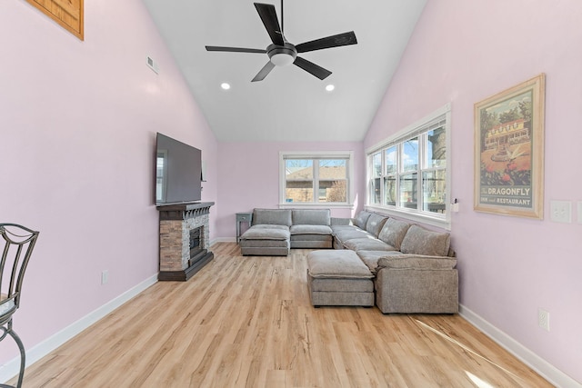 living room with a fireplace, high vaulted ceiling, ceiling fan, and wood finished floors