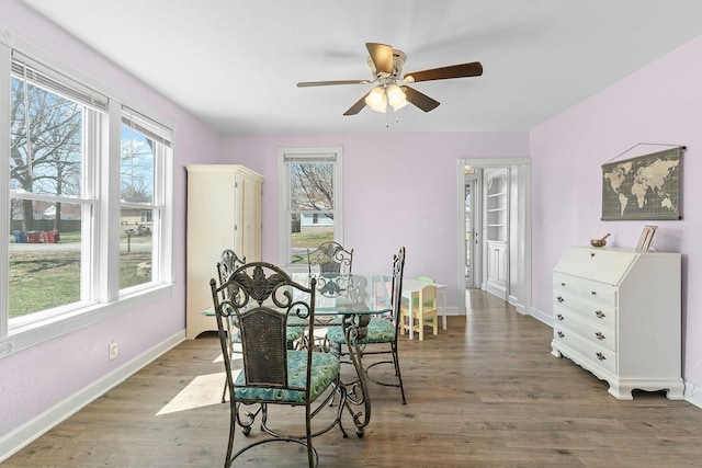 dining space featuring baseboards, wood finished floors, and a ceiling fan