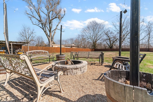 view of yard featuring an outdoor fire pit and fence