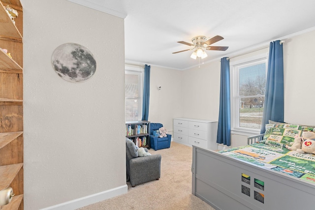 carpeted bedroom featuring a ceiling fan, crown molding, and baseboards