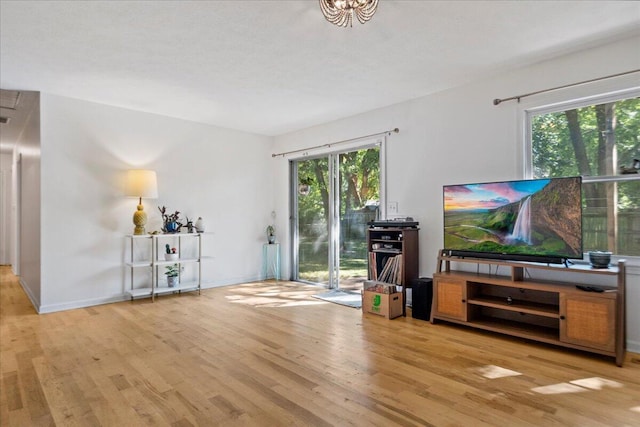 living area with plenty of natural light, light wood-style flooring, and baseboards