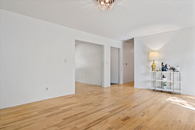 unfurnished room with baseboards and light wood finished floors