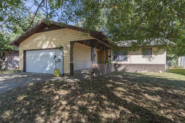 ranch-style home with aphalt driveway, an attached garage, covered porch, and a front yard