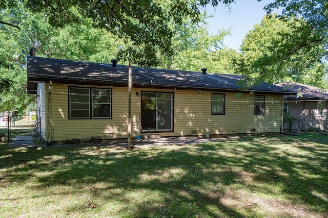 back of property with a lawn and fence