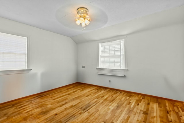 spare room with ceiling fan, baseboards, lofted ceiling, and hardwood / wood-style floors