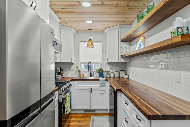 kitchen with a sink, butcher block countertops, wooden ceiling, appliances with stainless steel finishes, and open shelves