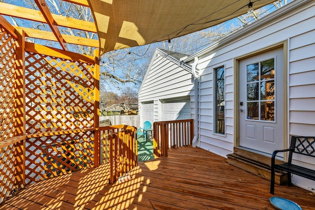 deck with a garage, a pergola, and fence