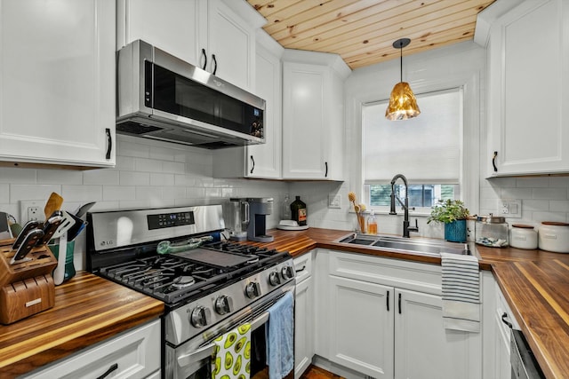 kitchen featuring a sink, white cabinets, stainless steel appliances, and wood counters