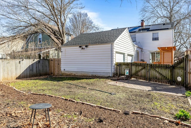 view of yard with fence, a garage, and a gate