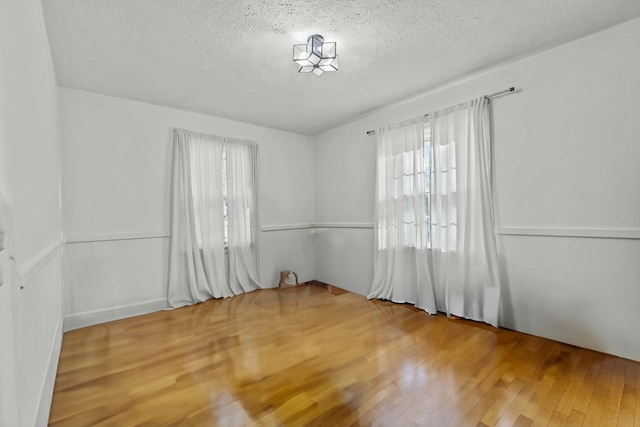 spare room featuring wood finished floors and a textured ceiling