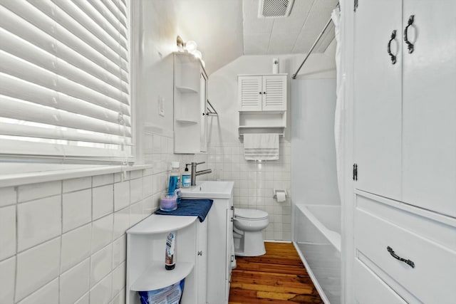 full bath with vanity, wood finished floors, visible vents, shower / bath combo with shower curtain, and toilet