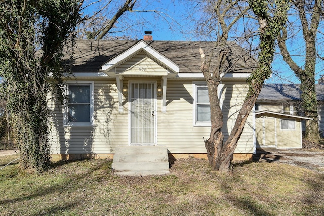 bungalow featuring roof with shingles and a chimney