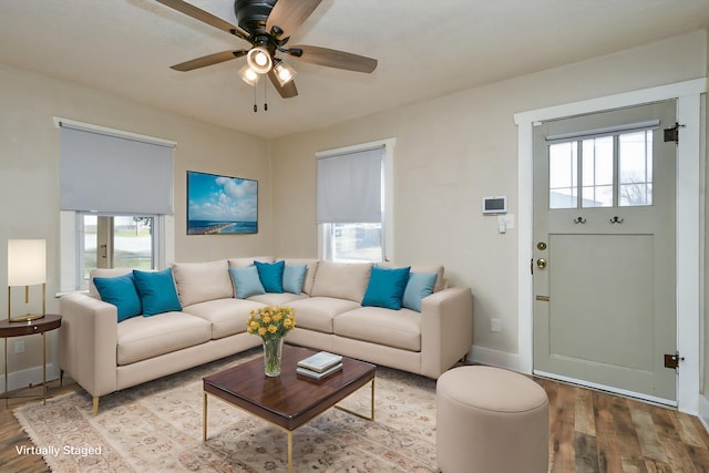 living room featuring wood finished floors, baseboards, a wealth of natural light, and ceiling fan