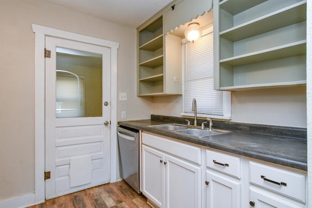 kitchen featuring dark countertops, a sink, dishwasher, and open shelves