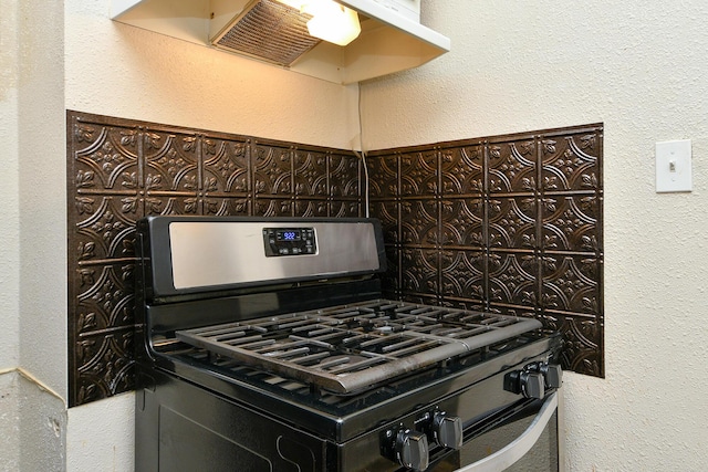 kitchen with decorative backsplash, gas range, a textured wall, and under cabinet range hood