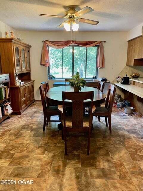 dining area featuring a textured ceiling and ceiling fan