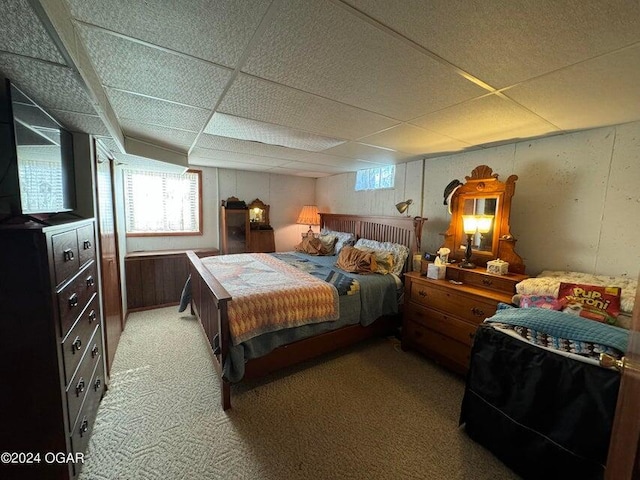 bedroom featuring light colored carpet and a paneled ceiling