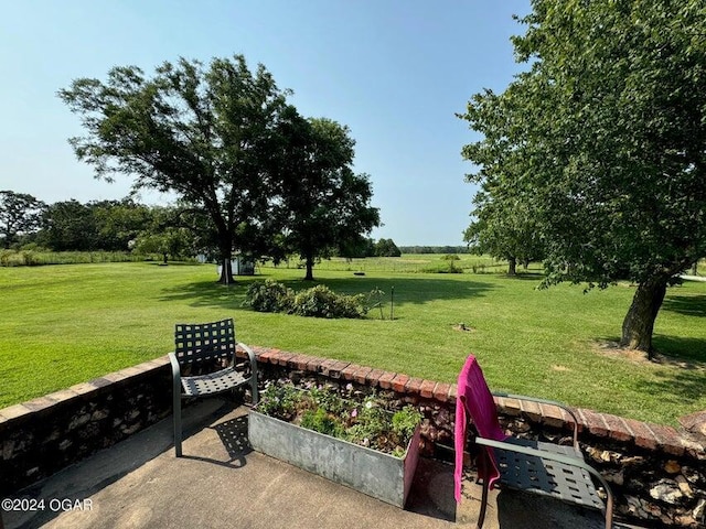 view of yard with a garden and a rural view