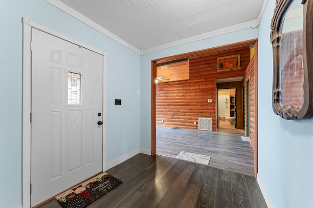 entryway featuring visible vents, a textured ceiling, dark wood-style floors, rustic walls, and baseboards