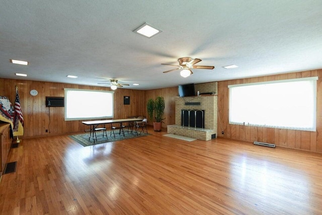 unfurnished living room featuring ceiling fan, visible vents, and wood finished floors