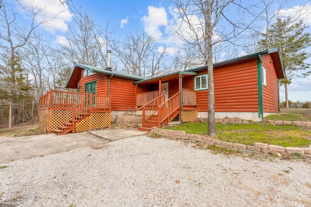 view of front of property with faux log siding and stairs