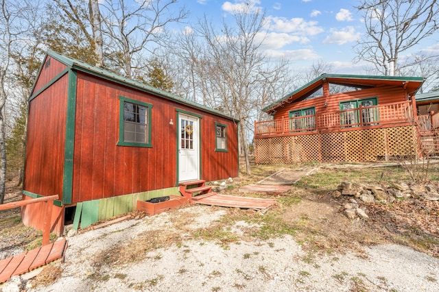 exterior space with a wooden deck, an outbuilding, and entry steps