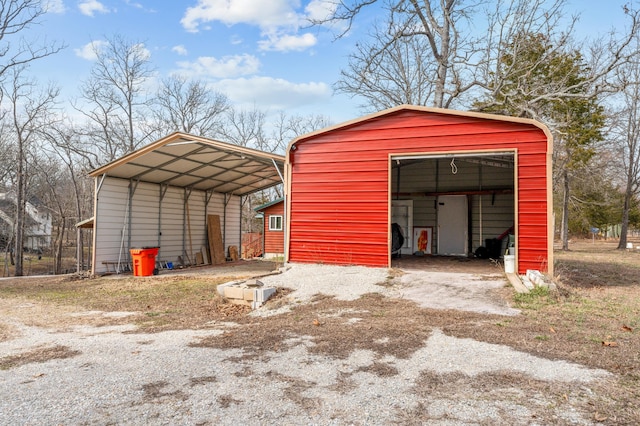 view of pole building with a carport and driveway