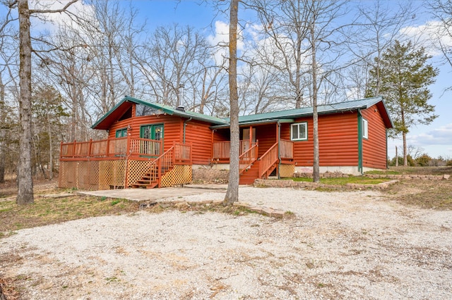 view of front facade featuring faux log siding and driveway