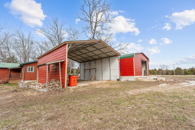 view of outdoor structure with an outbuilding, driveway, and a detached carport