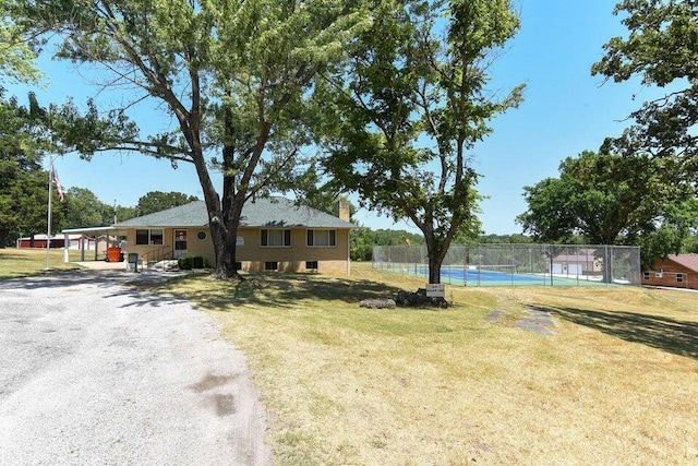 view of yard featuring a tennis court and fence