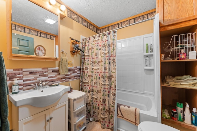 bathroom featuring toilet, vanity, a textured ceiling, and shower / tub combo