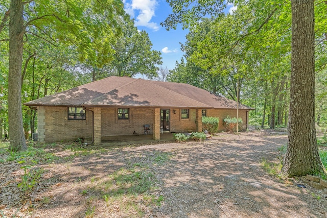 single story home with brick siding, roof with shingles, and driveway