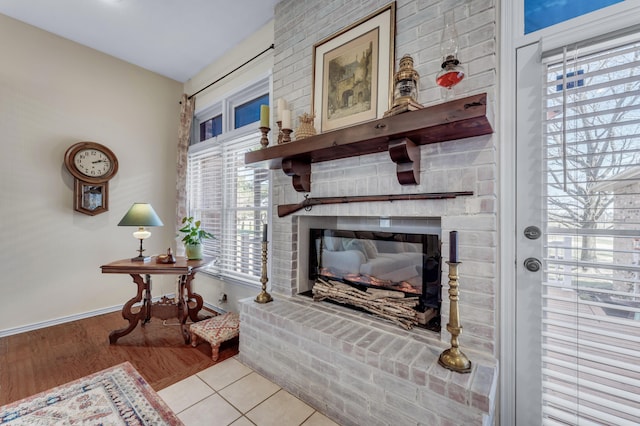 living area featuring baseboards, wood finished floors, and a fireplace