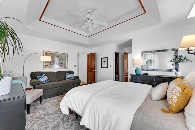 bedroom featuring a ceiling fan and a tray ceiling